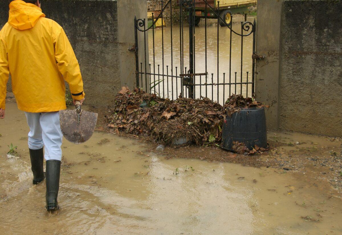 Foto van man die overstroming tuin probeert te stoppen