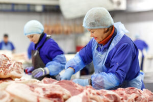 Twee vrouwen aan het werk in een slachterij