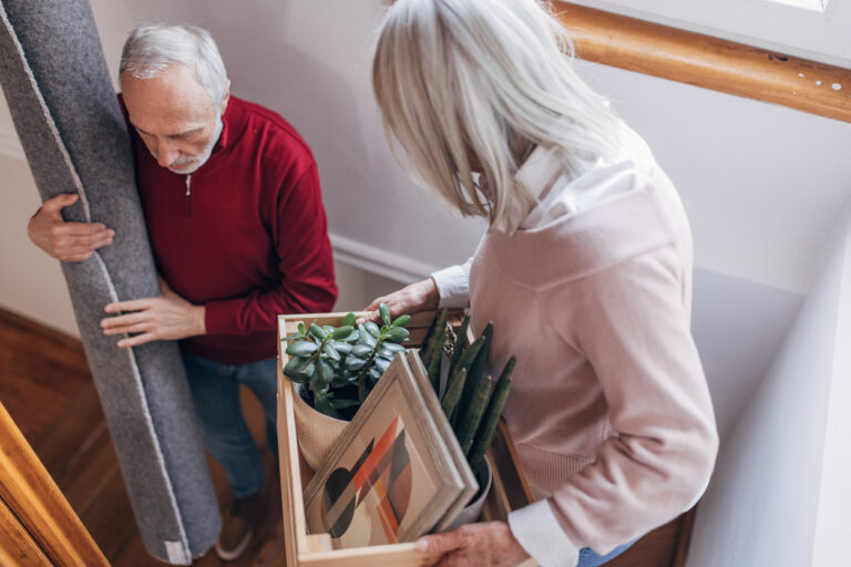 Oudere man en vrouw verhuizen spullen uit hun huis
